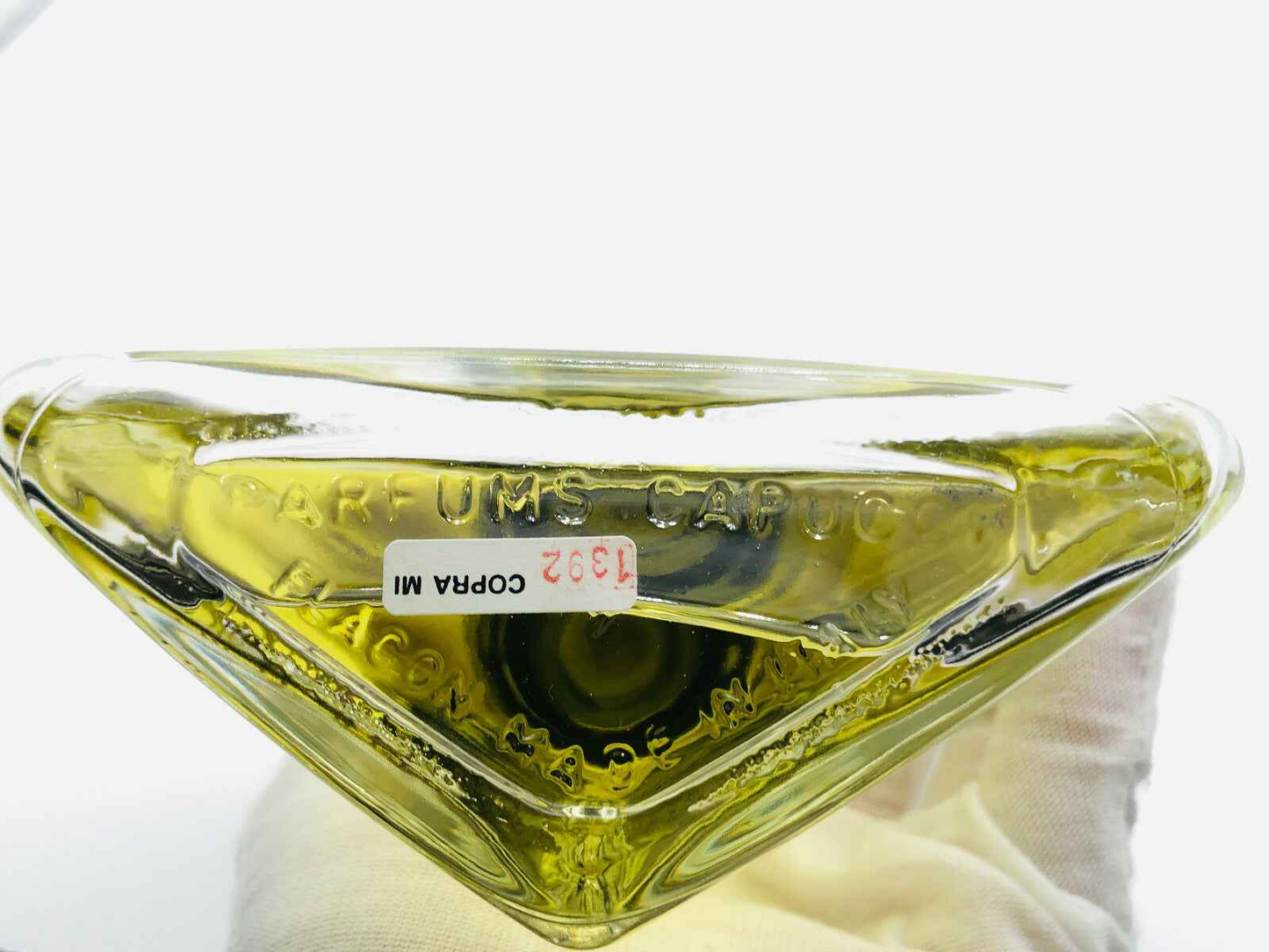 Bottiglia di profumo Roberto Capucci in formato triangolare con liquidità gialla e etichetta trasparente