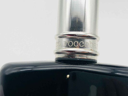 Dettaglio del flacone di profumo Roccobarocco Vintage con tappo argentato e design elegante