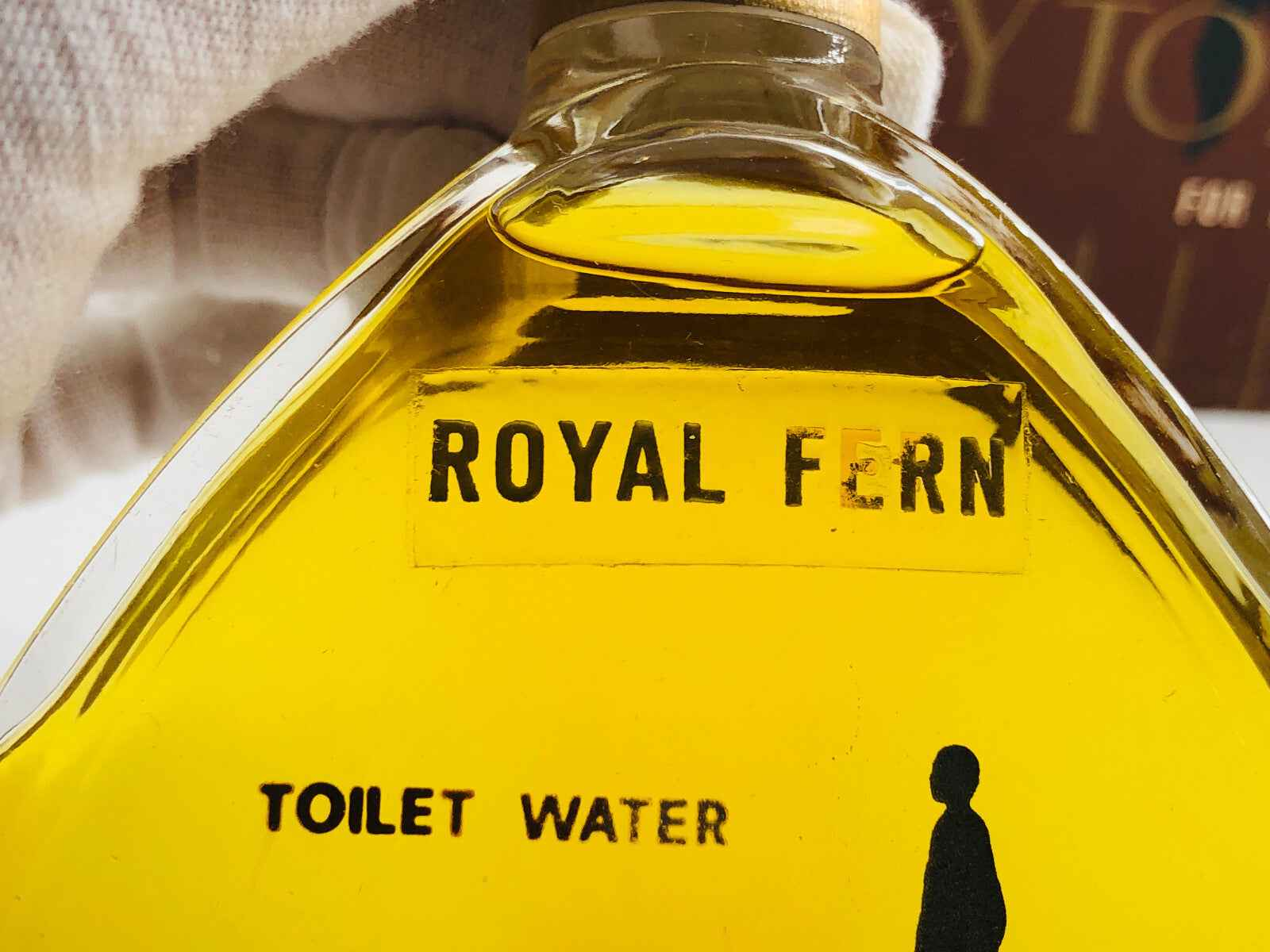 Bottiglia di profumo Royal Fern con etichetta Toilet Water e liquido giallo dorato
