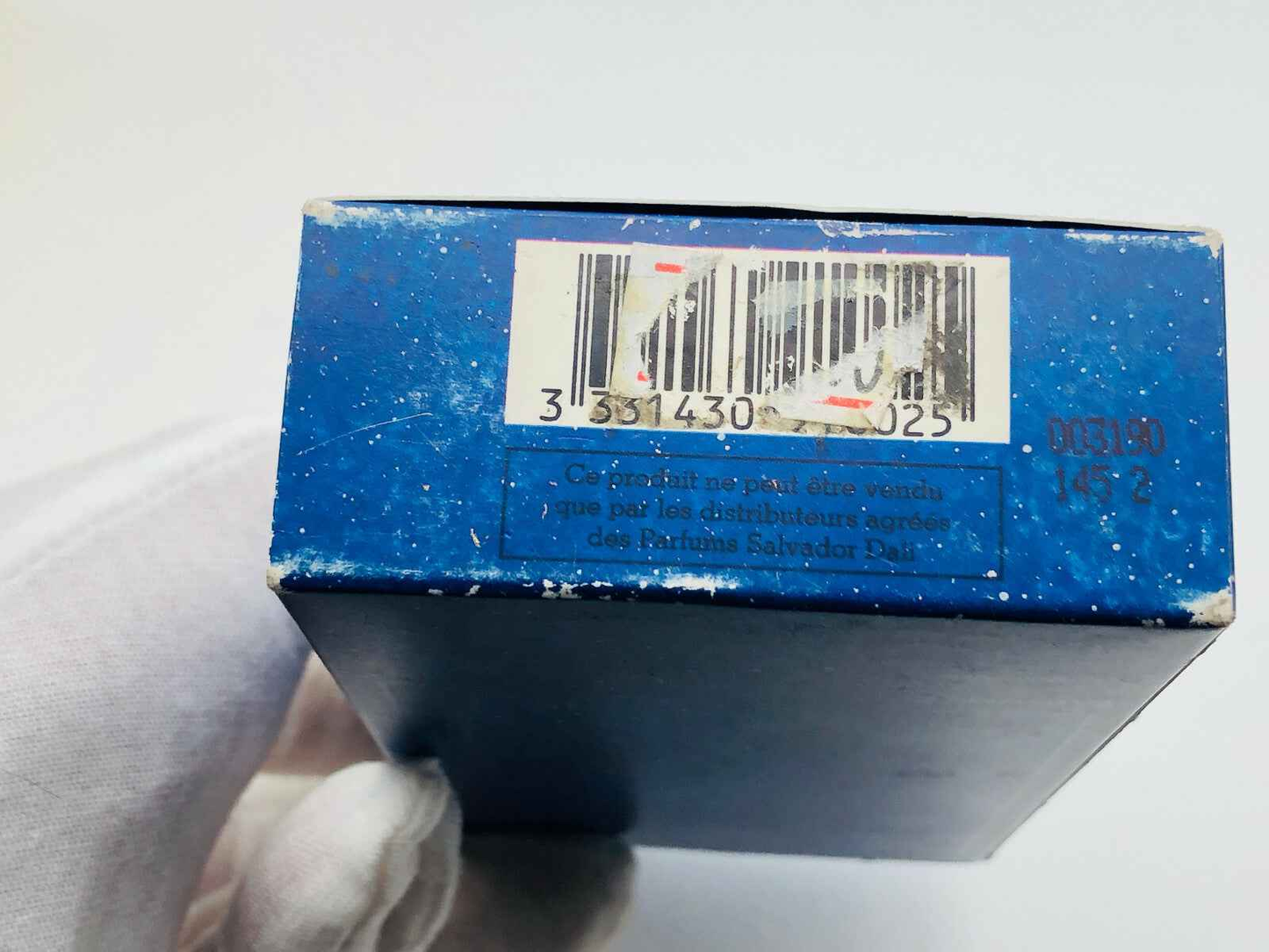 Scatola di profumo Salvador Dali in blu con codice a barre e dettagli del prodotto sulla parte inferiore