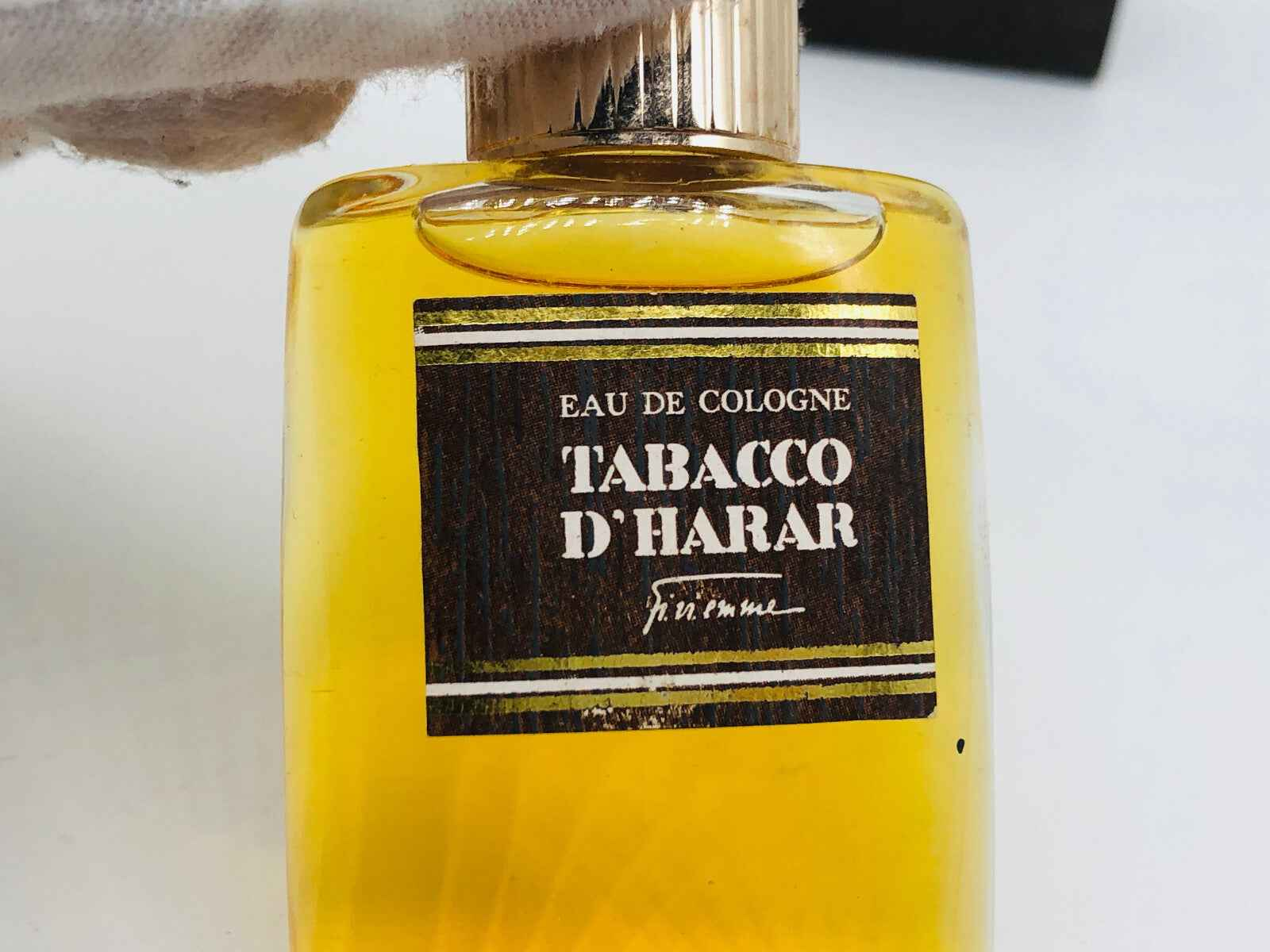 Flacone di profumo Tabacco D Harar con etichetta elegante e liquido dorato