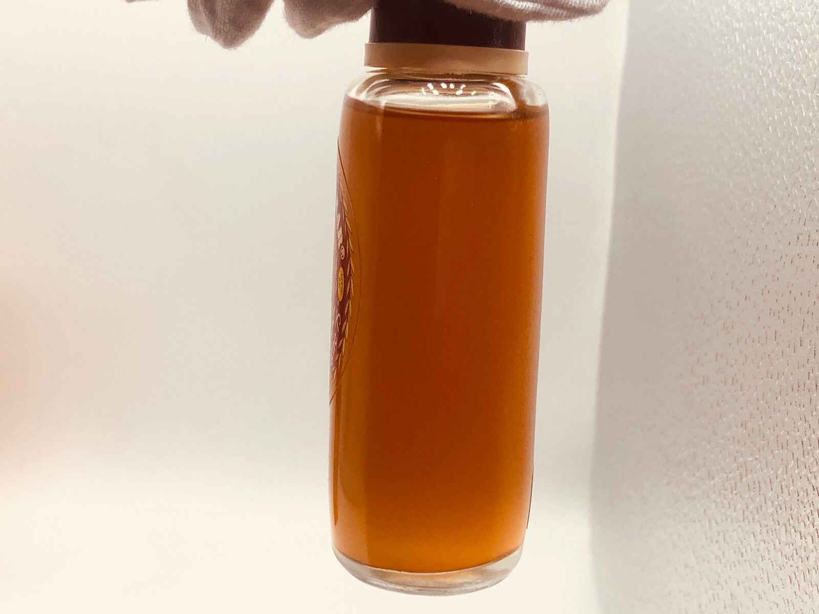 Flacone di profumo Tabacco Harar Vintage con liquido ambrato e design elegante