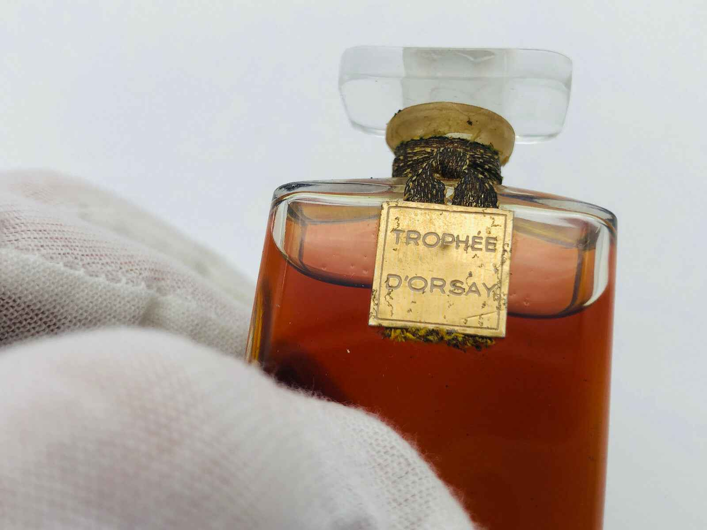 Bottiglia di profumo Trophee D Orsay con etichetta dorata e liquido ambrato