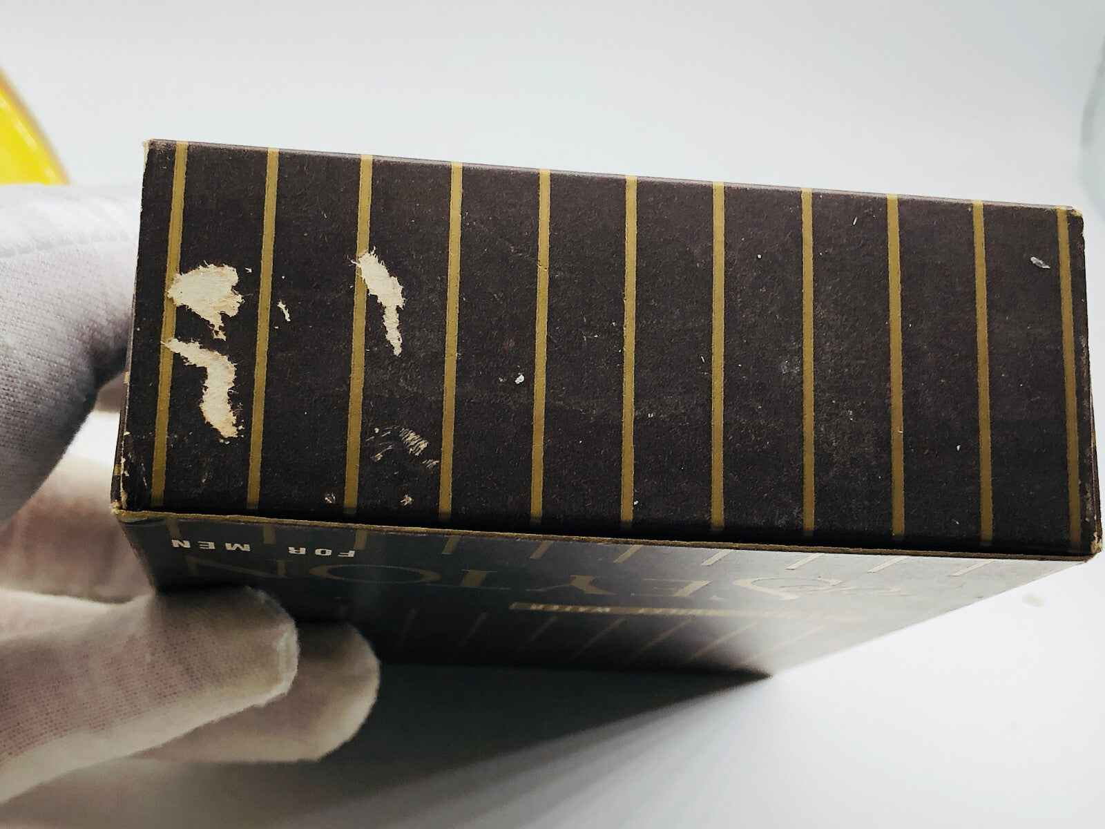 Scatola del profumo Vic Seyton Tobacco con design elegante e strisce dorate, vista dall'alto