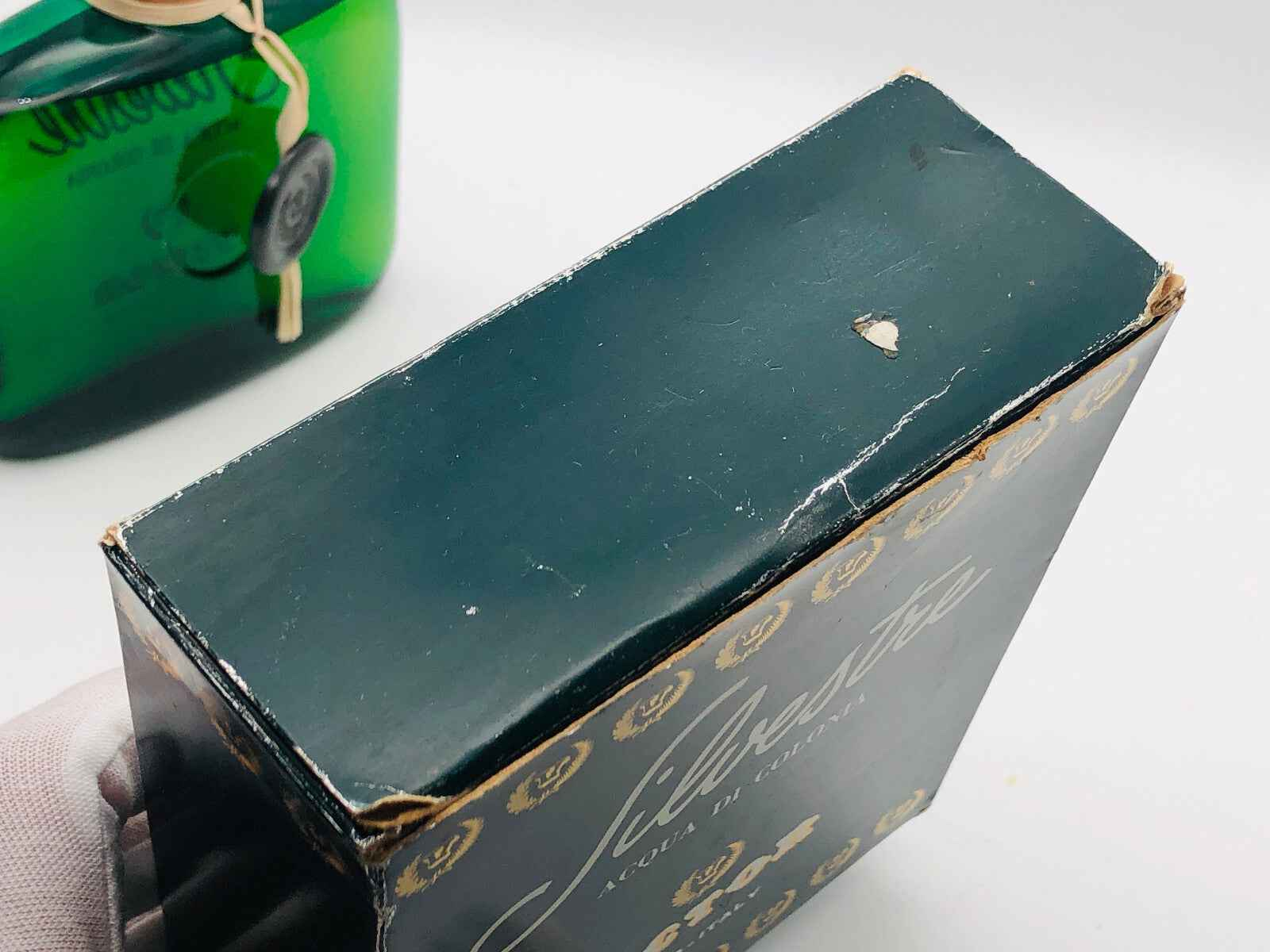 Scatola di profumo Victor Silvestre con dettagli dorati e segni di usura visibili