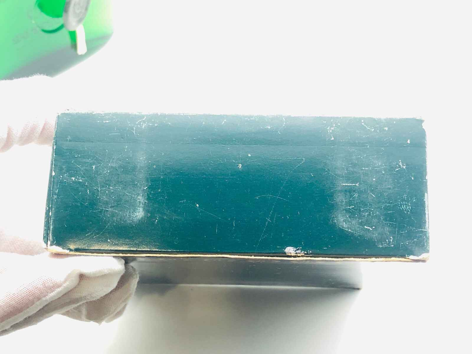Scatola del profumo Victor Silvestre con finitura verde e segni di utilizzo