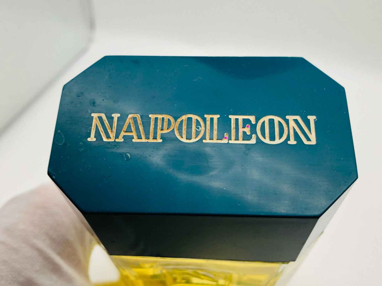 Dettaglio del tappo del flacone di profumo Vintage Napoleon con logo dorato in rilievo