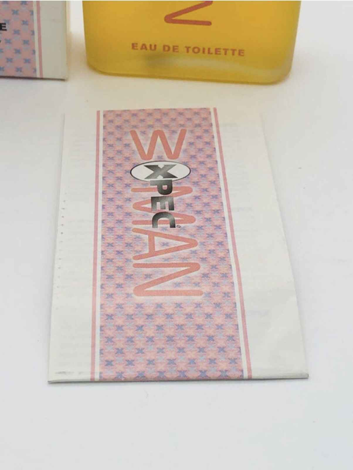 Campione di profumo Xpec Woma con design elegante e logo distintivo per una fragranza femminile