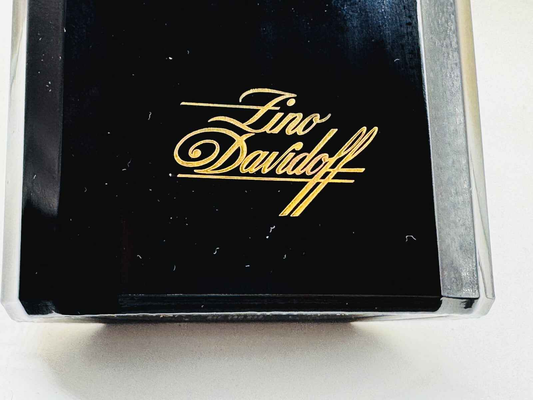 Dettaglio della confezione del Profumo Zino Davidoff Vintage con logo dorato su sfondo nero
