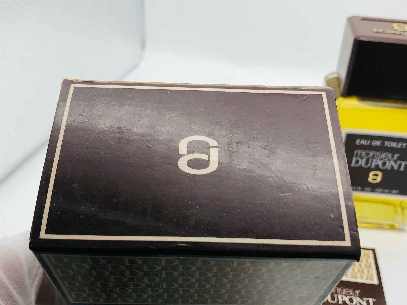 Scatola del profumo Richard Dupont con logo elegante in superficie lucida marrone