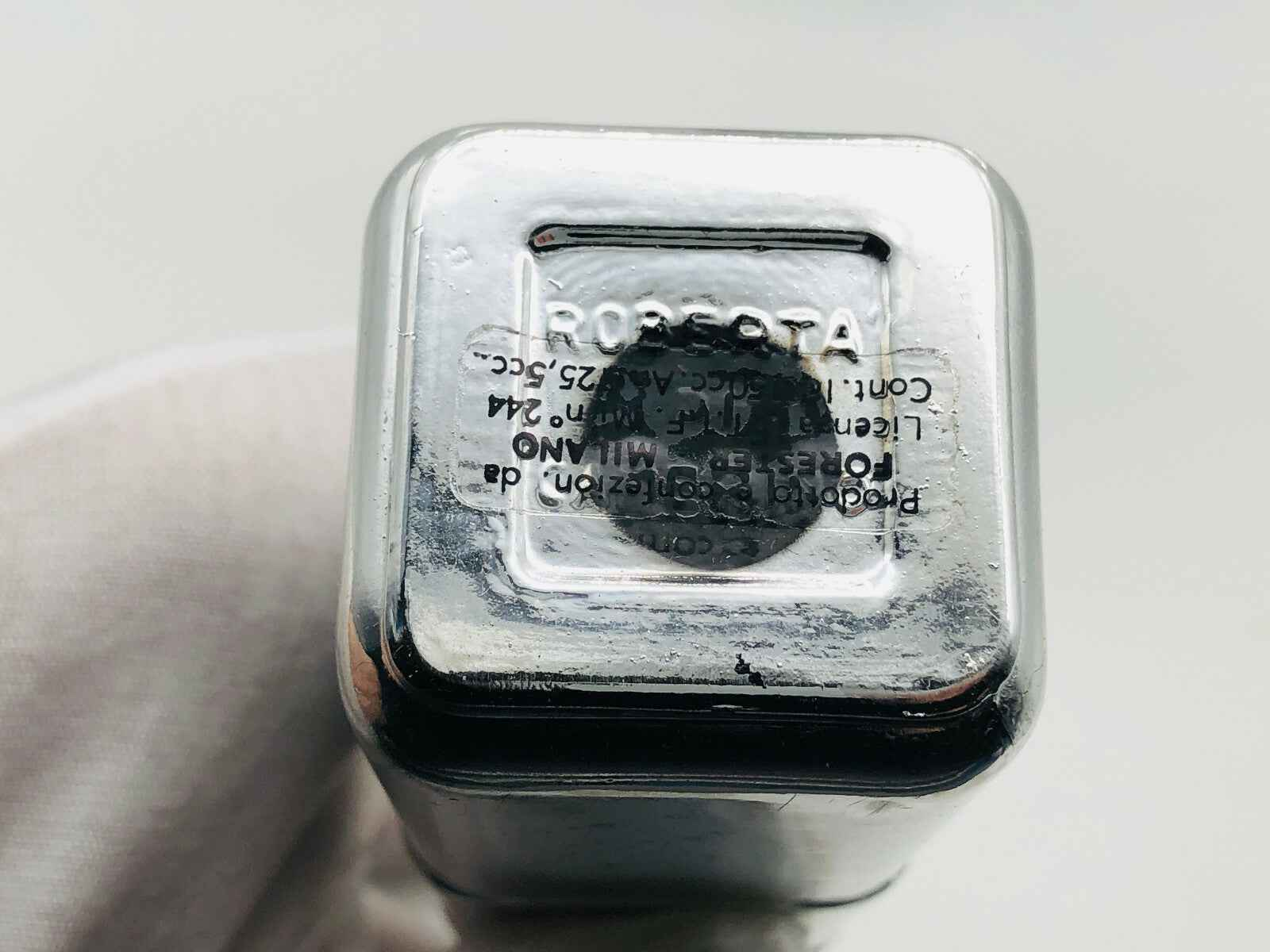 Dettaglio del fondo di un flacone di profumo Roberta Di Camerino Vintage con scritte in rilievo