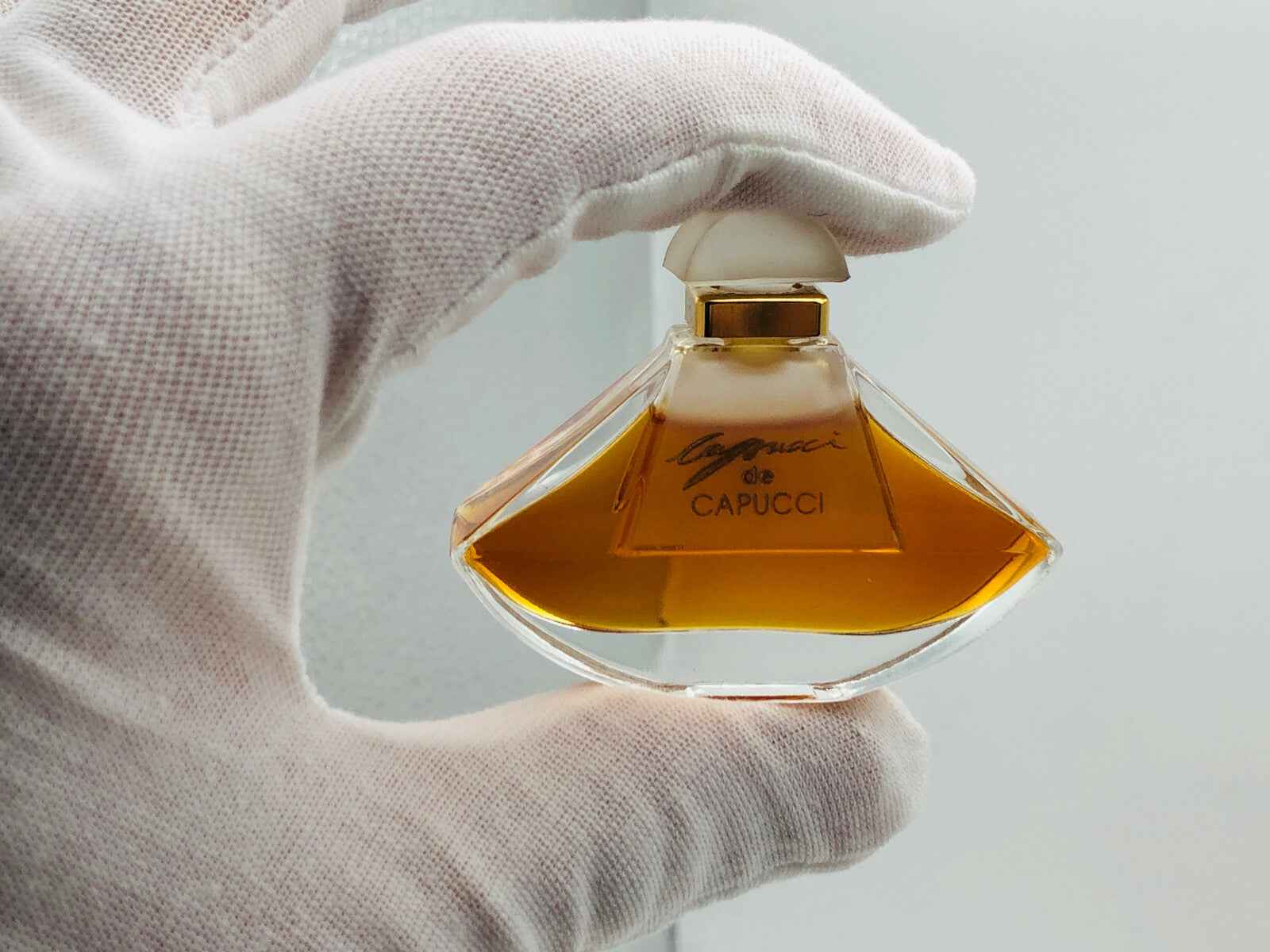Flacone di profumo vintage Roberto Capucci con design elegante e tonalità ambrate