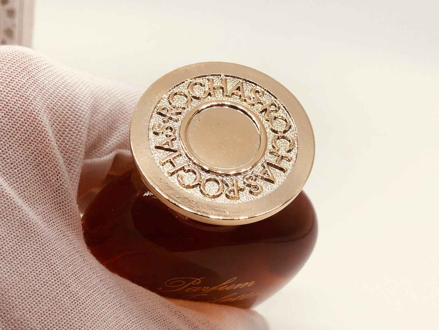 Tappo profumo Rochas Femme Vintage con logo dorato in evidenza su flacone elegante