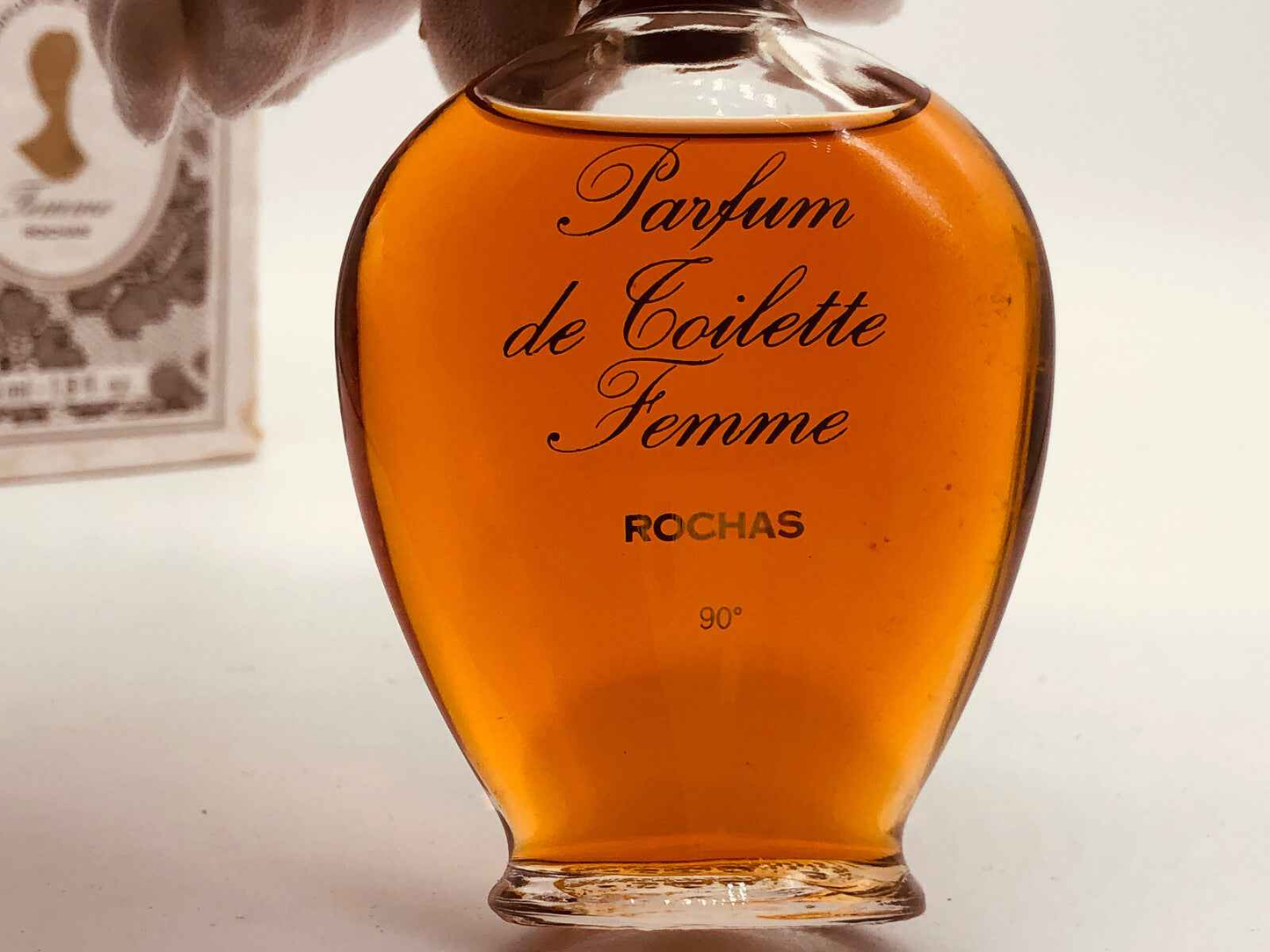 Flacone di profumo vintage Rochas Femme con etichetta elegante e liquido ambrato