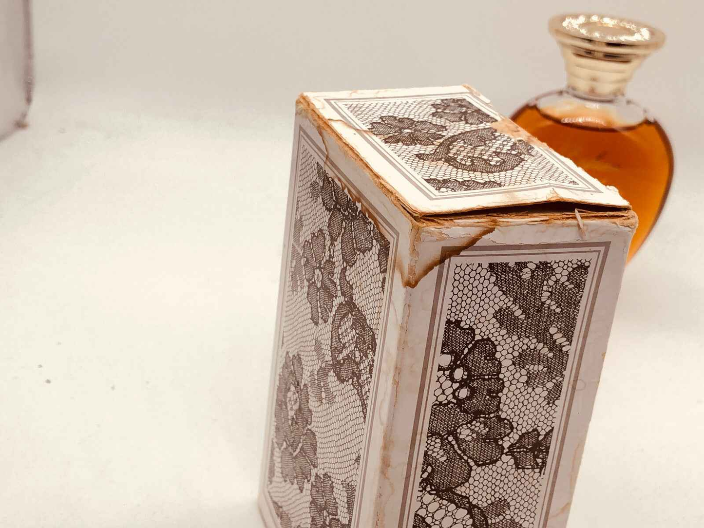 Scatola vintage di Rochas Femme con dettagli floreali e profumo sullo sfondo