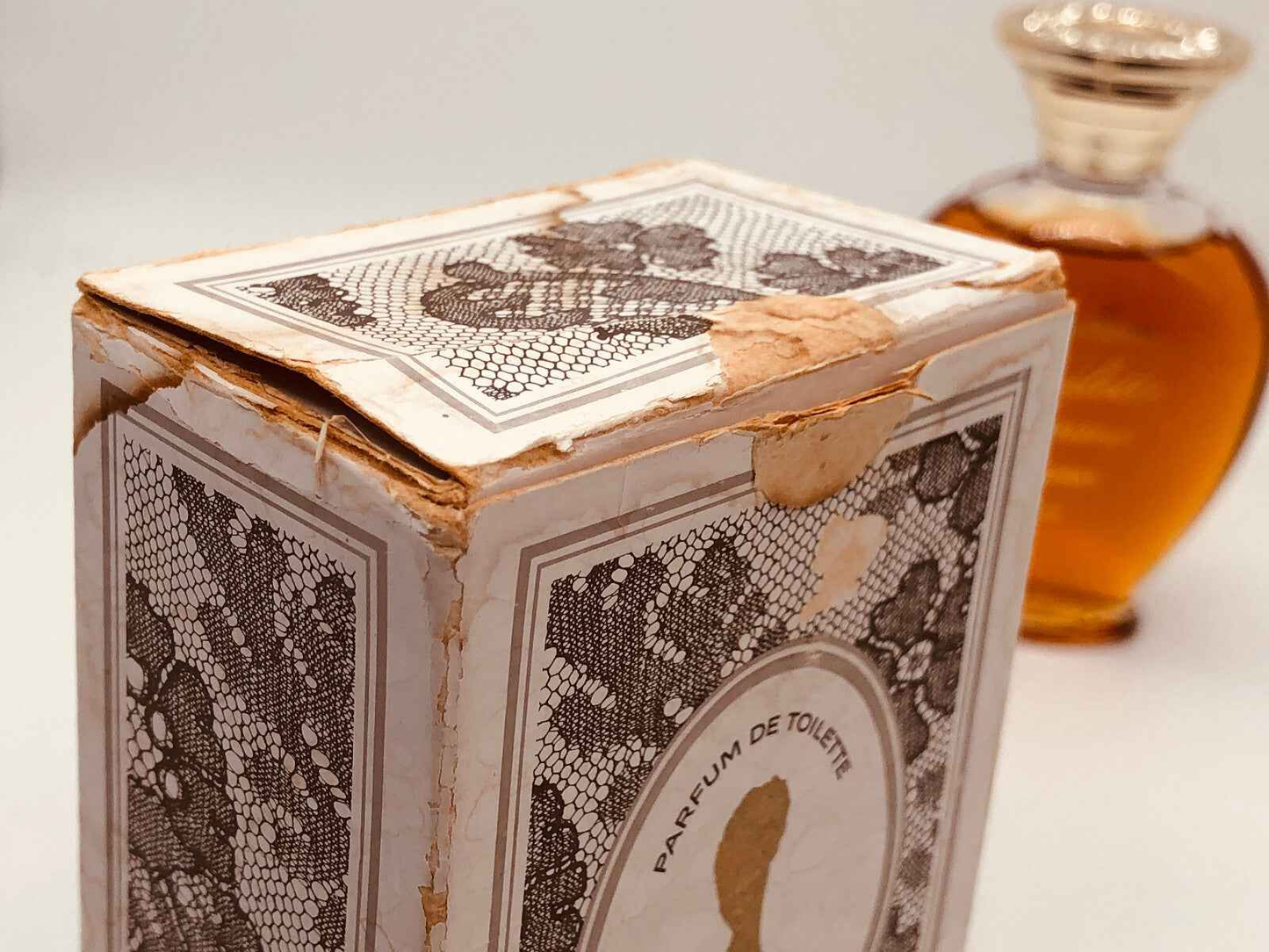 Scatola vintage di Rochas Femme Vintage con profumo in bottiglia elegante sullo sfondo