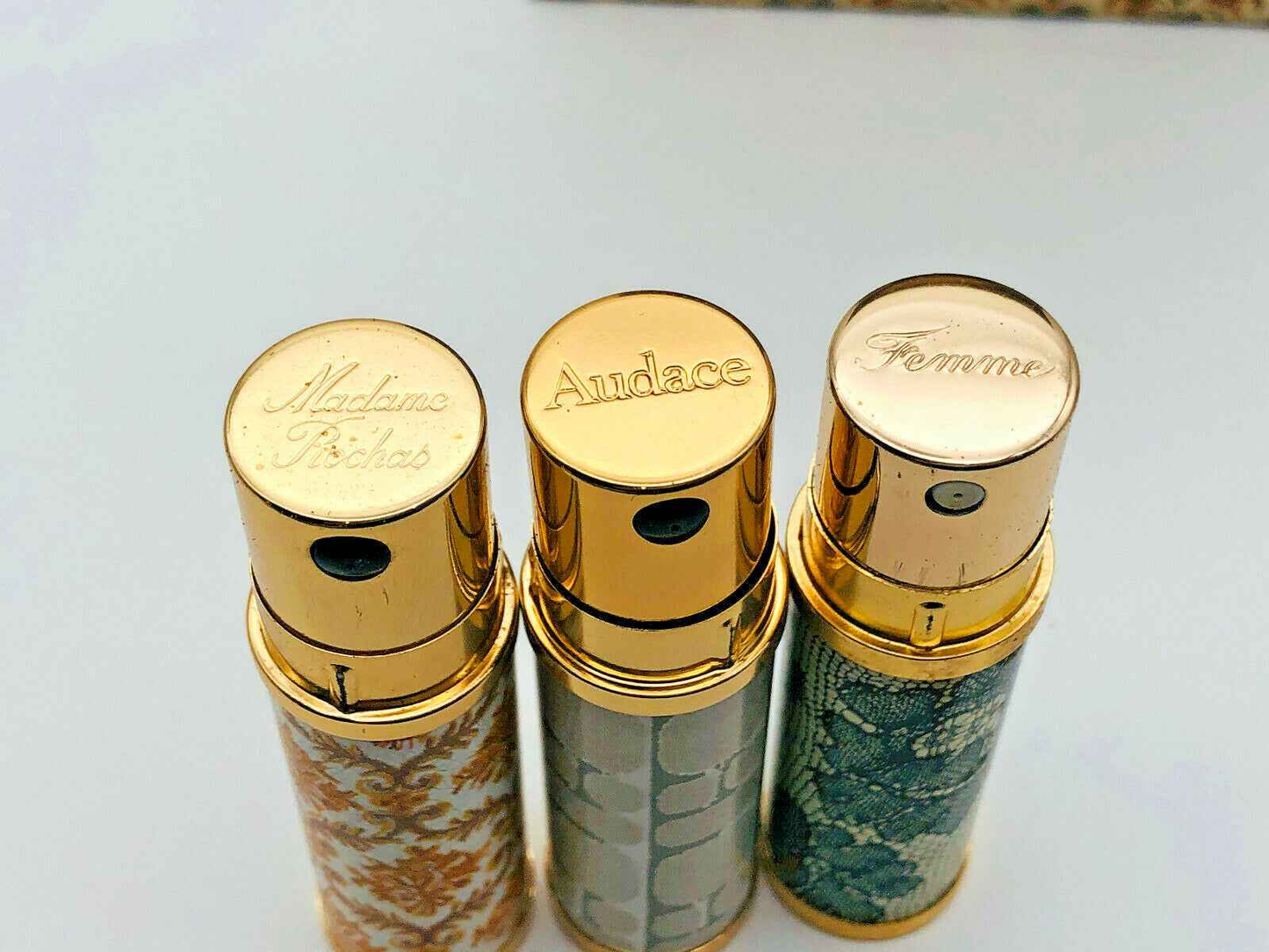 Tre flaconi di Rochas Parfum Extrait Vintage con tappi dorati e design elegante