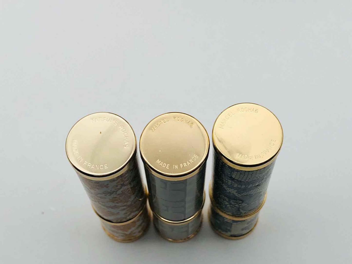 Flaconi di Rochas Parfum Extrait Vintage impilati con tappi dorati, eleganti ed esclusivi.