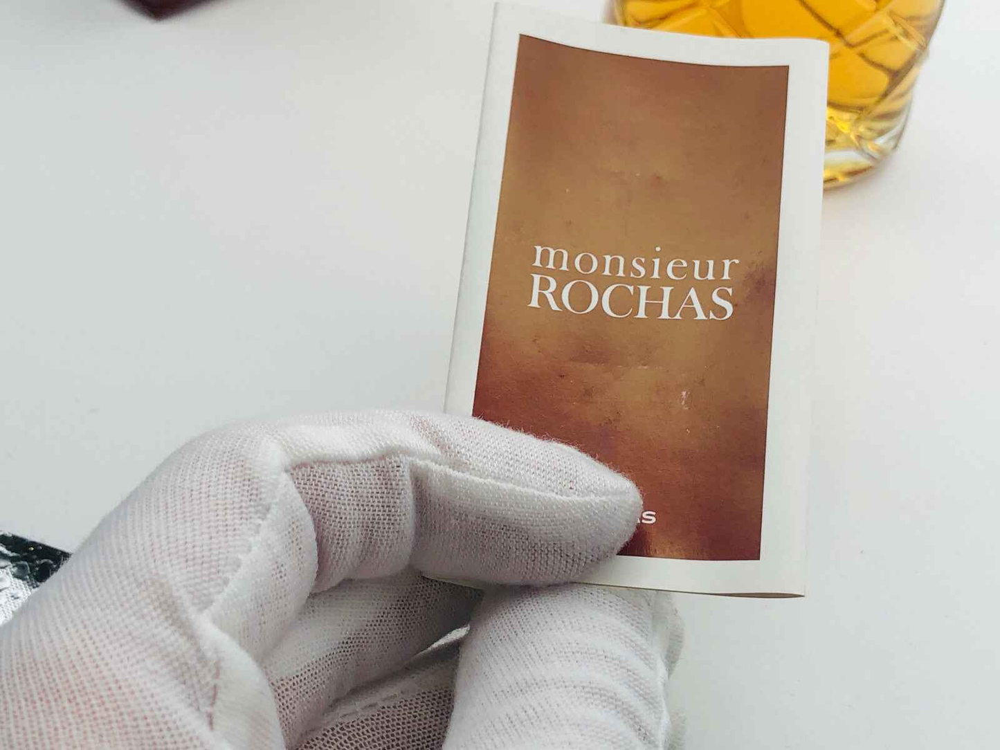 Campione di profumo Rochas Monsieur Vintage in confezione elegante con flacone dorato sullo sfondo