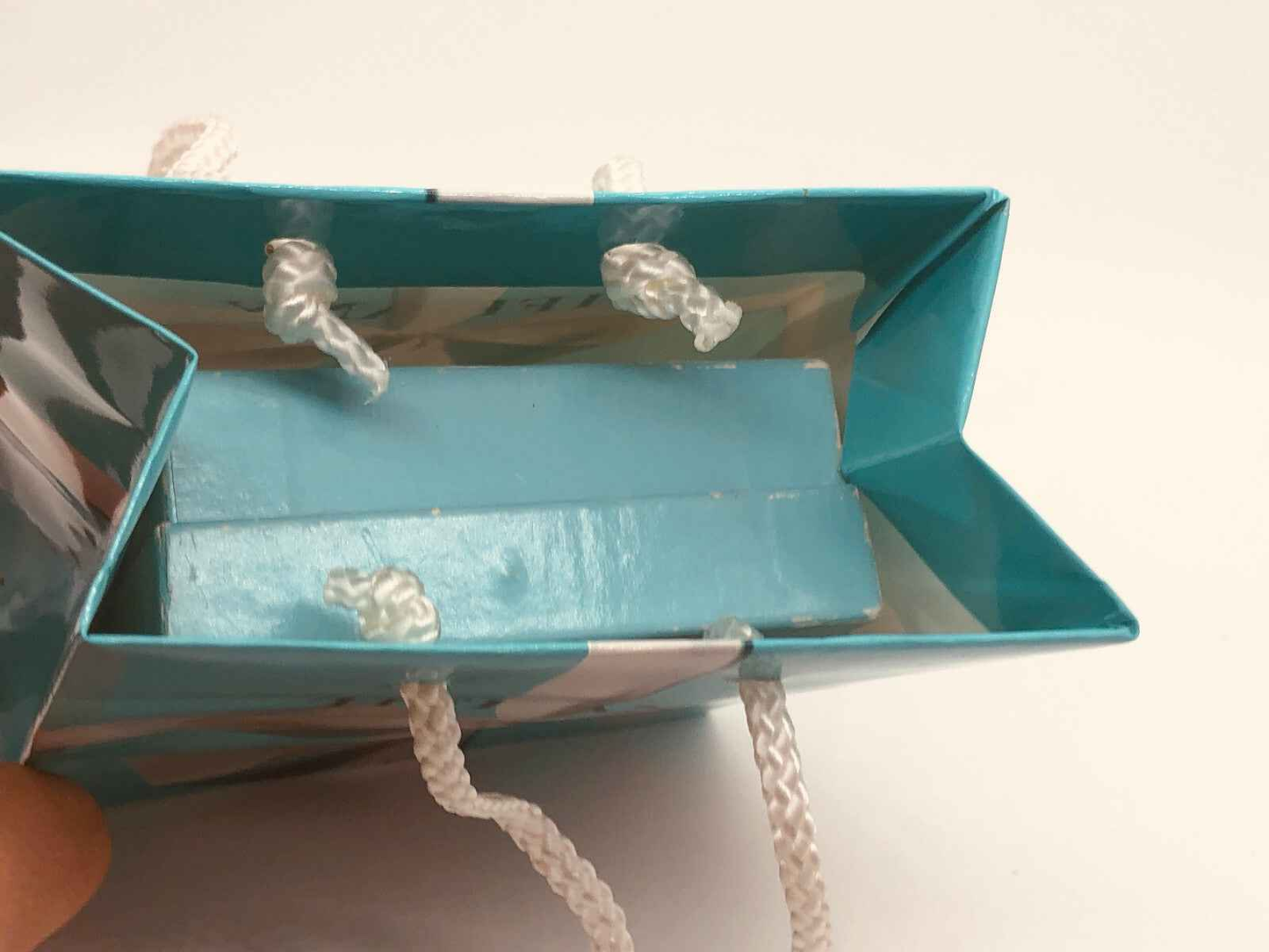 Borsa Tiffany & Co. in azzurro, contenente il profumo Tiffany Vintage Donna, elegante e raffinato.
