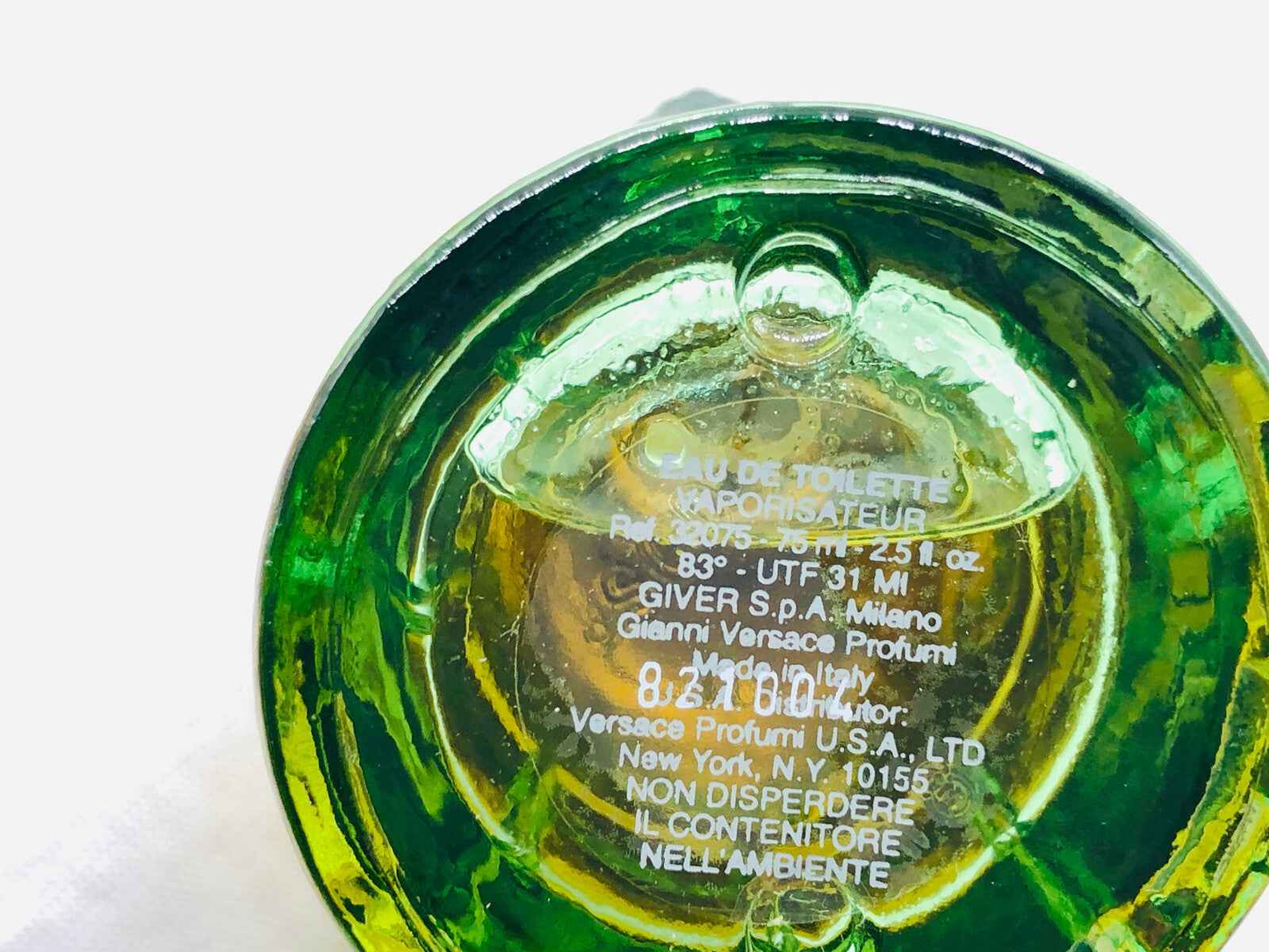 Flacone di profumo Versace Green Jeans con design verde e testo in rilievo sul fondo