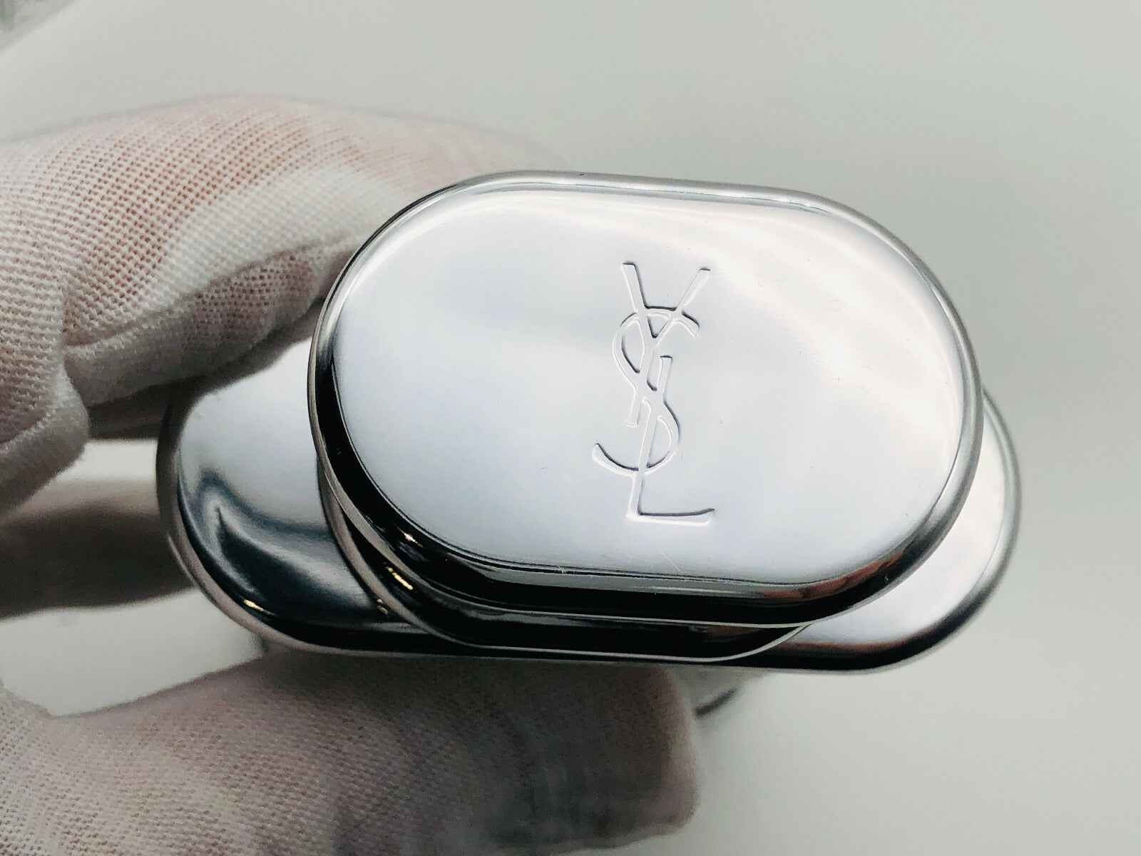 Flacone in metallo argentato con logo YSL per il profumo Ysl Kouros Vintage di Yves Saint Laurent