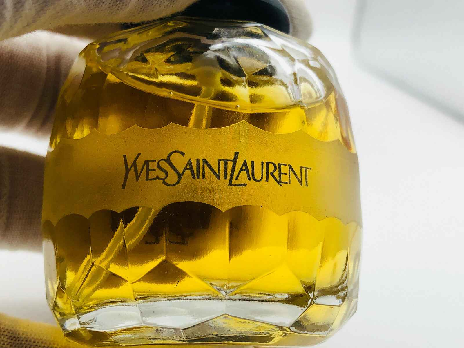 Flacone di profumo Ysl Paris con design elegante di Yves Saint Laurent in vetro dorato