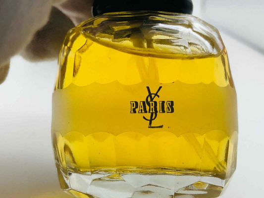 Flacone di profumo Ysl Paris con liquido giallo in un design elegante