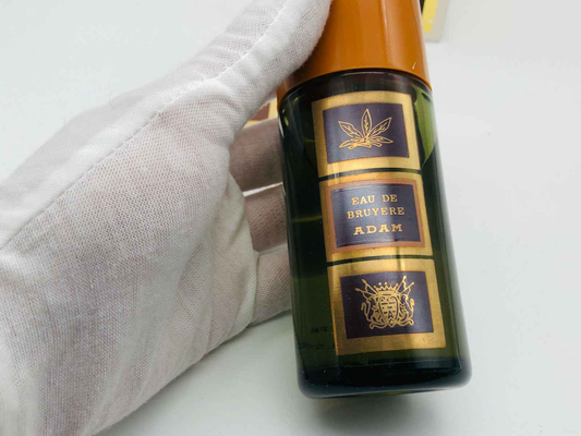 Flacone di ADAM EAU DE BRUYERE VINTAGE profumo con etichetta distintiva e tappo arancione