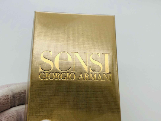 Scatola del profumo Armani Sensi in oro con logo Giorgio Armani in rilievo
