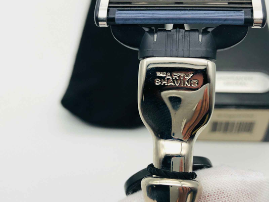 Dettaglio del manico lucido dell'Art Of Shaving Rasoio con logo distintivo e design elegante