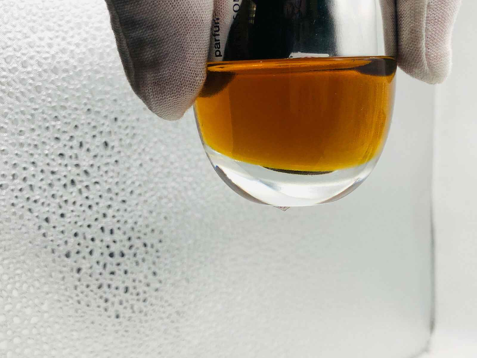 Flacone di profumo Atkinsons Espiegle con liquido ambrato in evidenza e fondo bianco