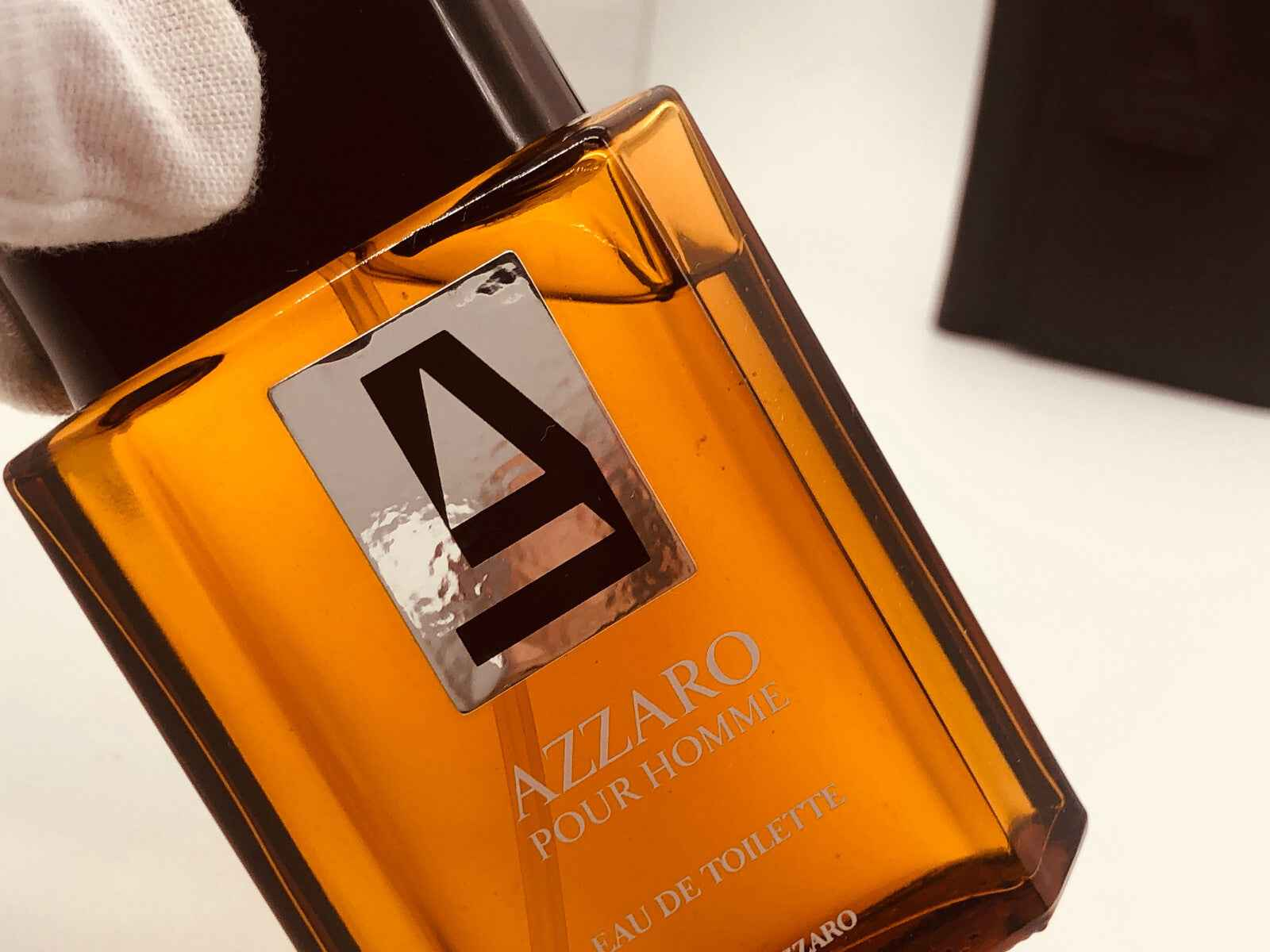 Flacone di profumo Azzaro Pour Homme profumo vintage con design classico e tonalità arancione distintiva