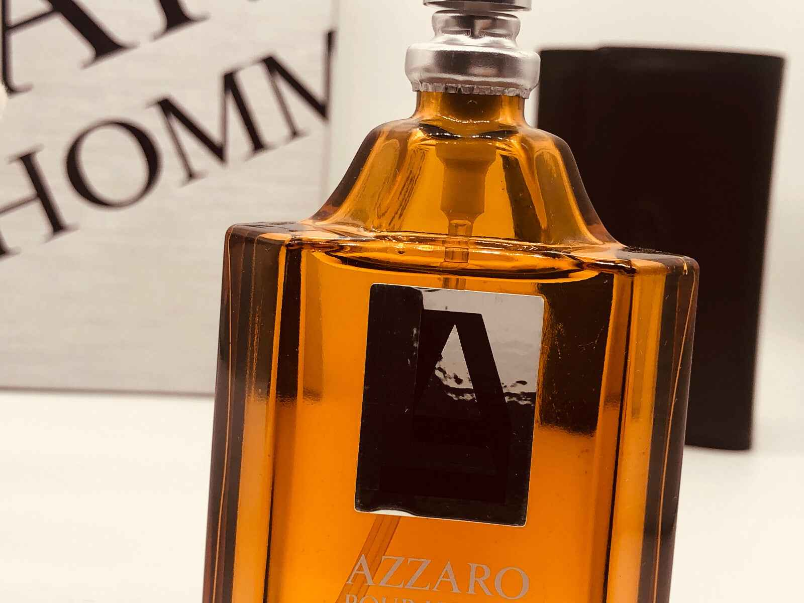 Flacone di Azzaro Pour Homme profumo vintage in vetro arancione con logo distintivo