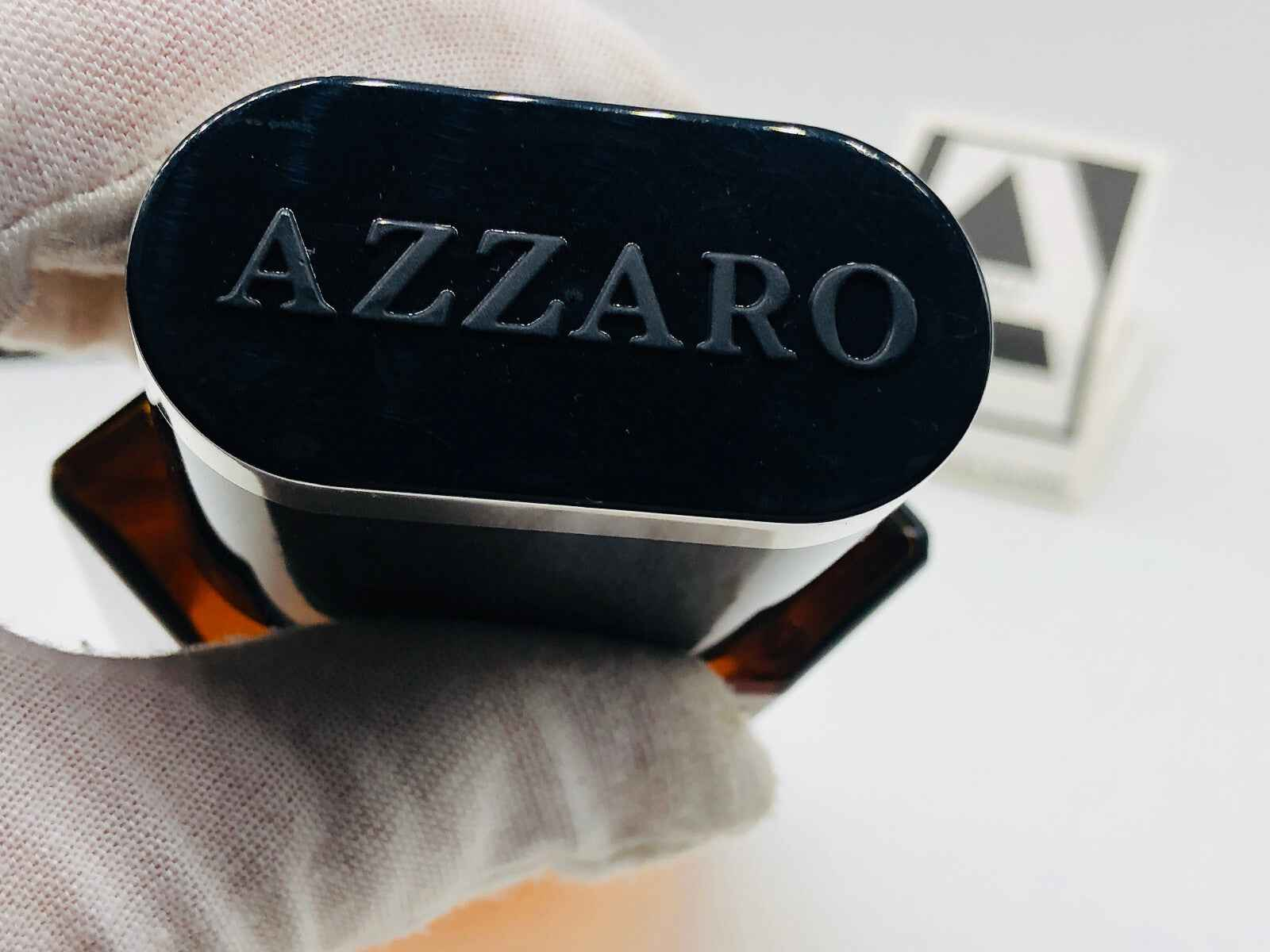 Dettaglio del tappo del profumo Azzaro Pour Homme Vintage con logo in rilievo