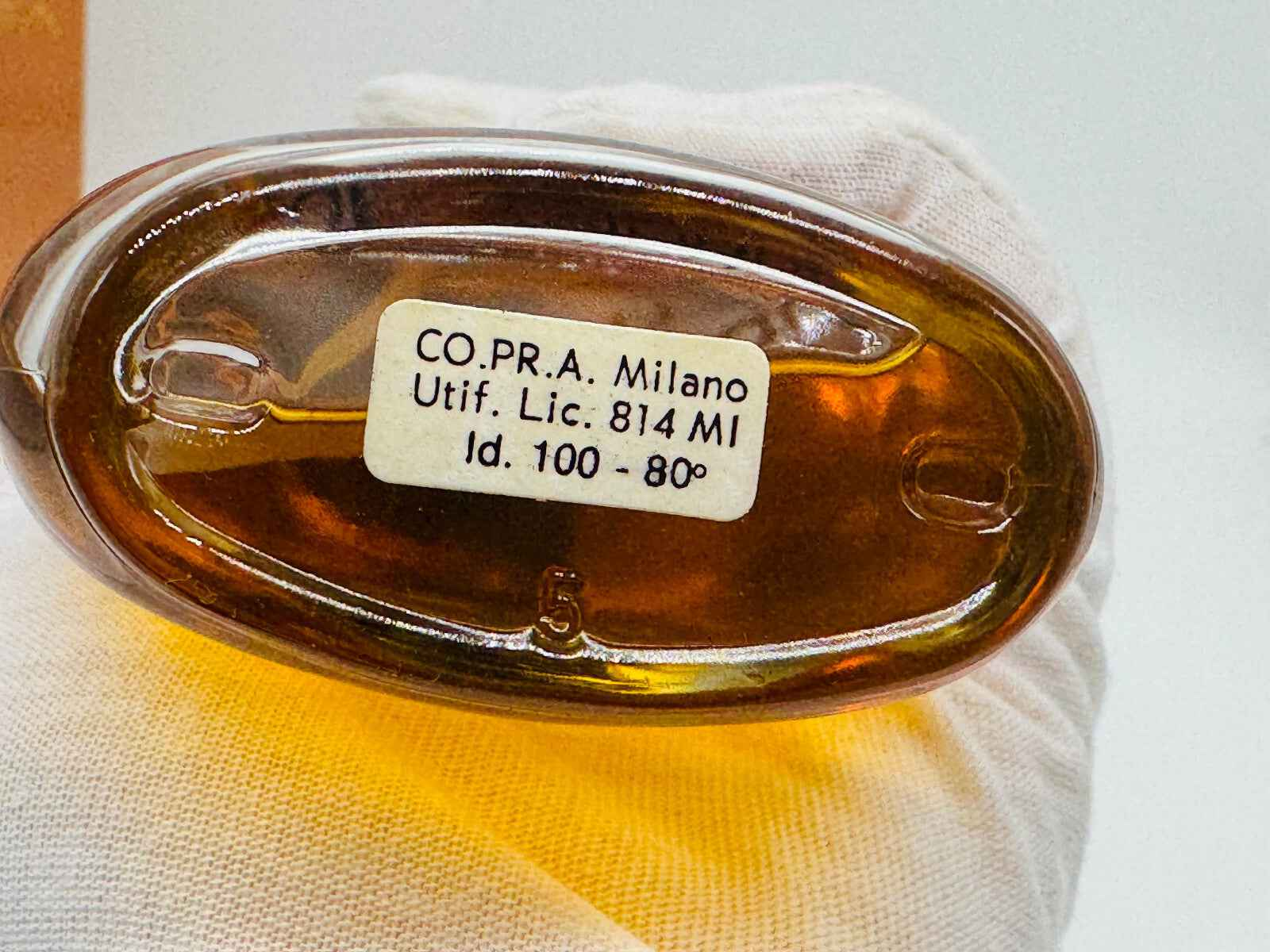 Base del flacone di profumo Balenciaga Portos Vintage con etichetta identificativa e tonalità ambrata