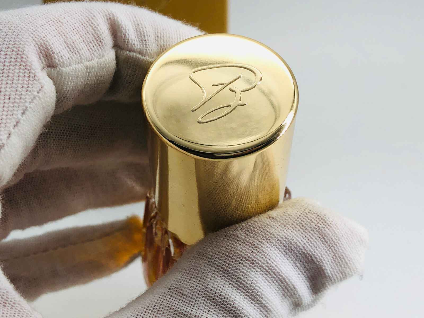 Dettaglio del tappo dorato del profumo BARATTA VINTAGE con logo elegante e design raffinato