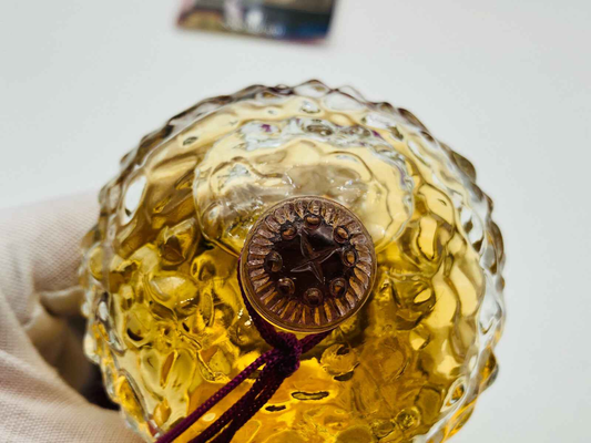Dettaglio di un profumo vintage Borsari con tappo decorativo in rilievo e bottiglia in vetro ondulato