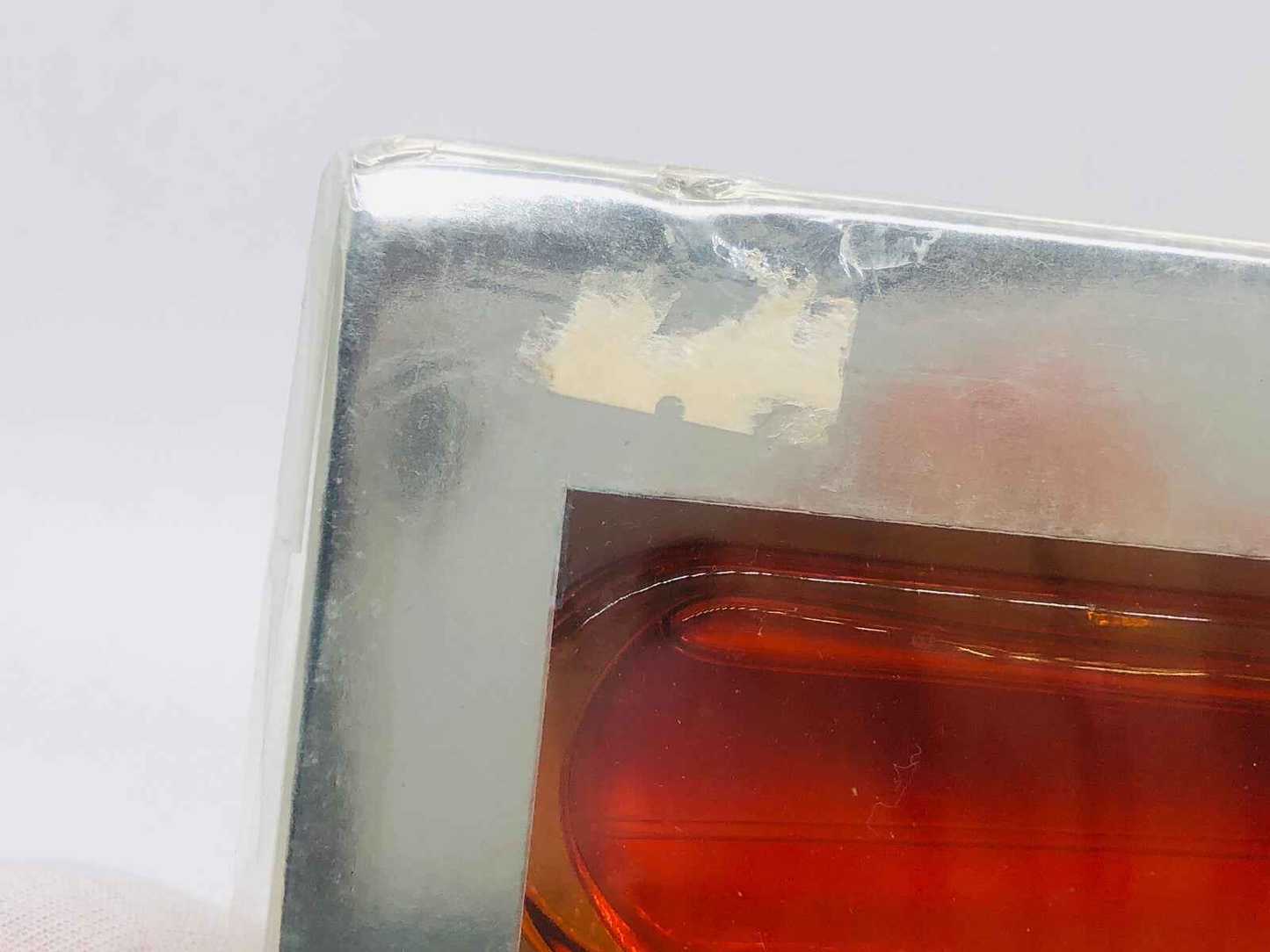 Scatola del profumo Cartier Must con finitura argento e dettaglio in vetro arancione