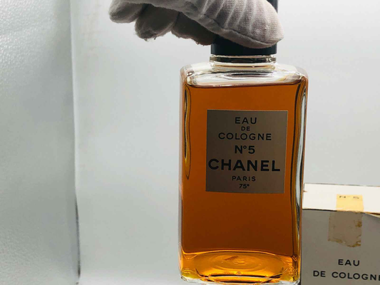 Flacone di Profumo Chanel N 5 Vintage con etichetta elegante in una mano guantata