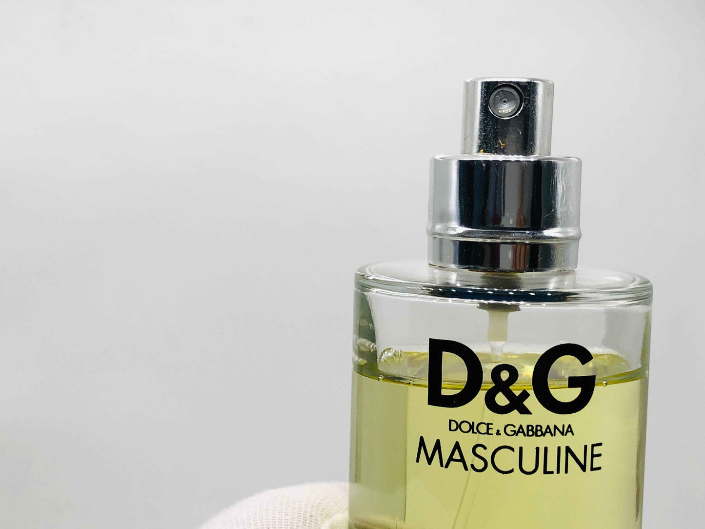 Flacone di profumo Dolce E Gabbana Masculine con spray argentato e liquido dorato