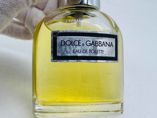 Flacone di profumo Dolce & Gabbana Pour Homme in vetro con etichetta elegante e liquido giallo