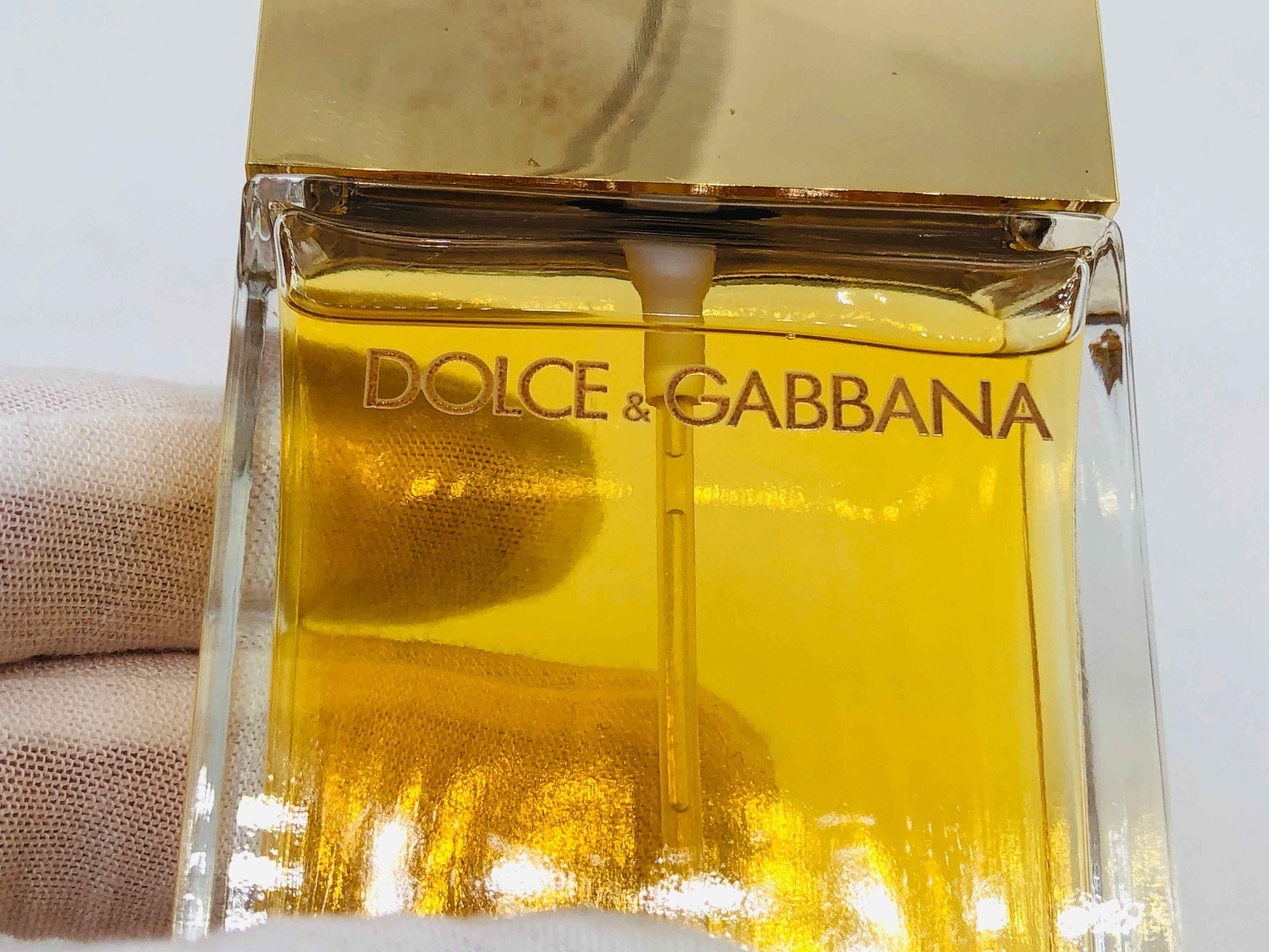 Profumo Dolce E Gabbana in un elegante flacone trasparente con un tappo dorato, ideale per ogni occasione