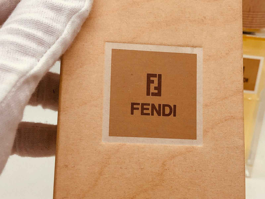 Confezione di Profumo Fendi Life Essence con logo Fendi su sfondo neutro
