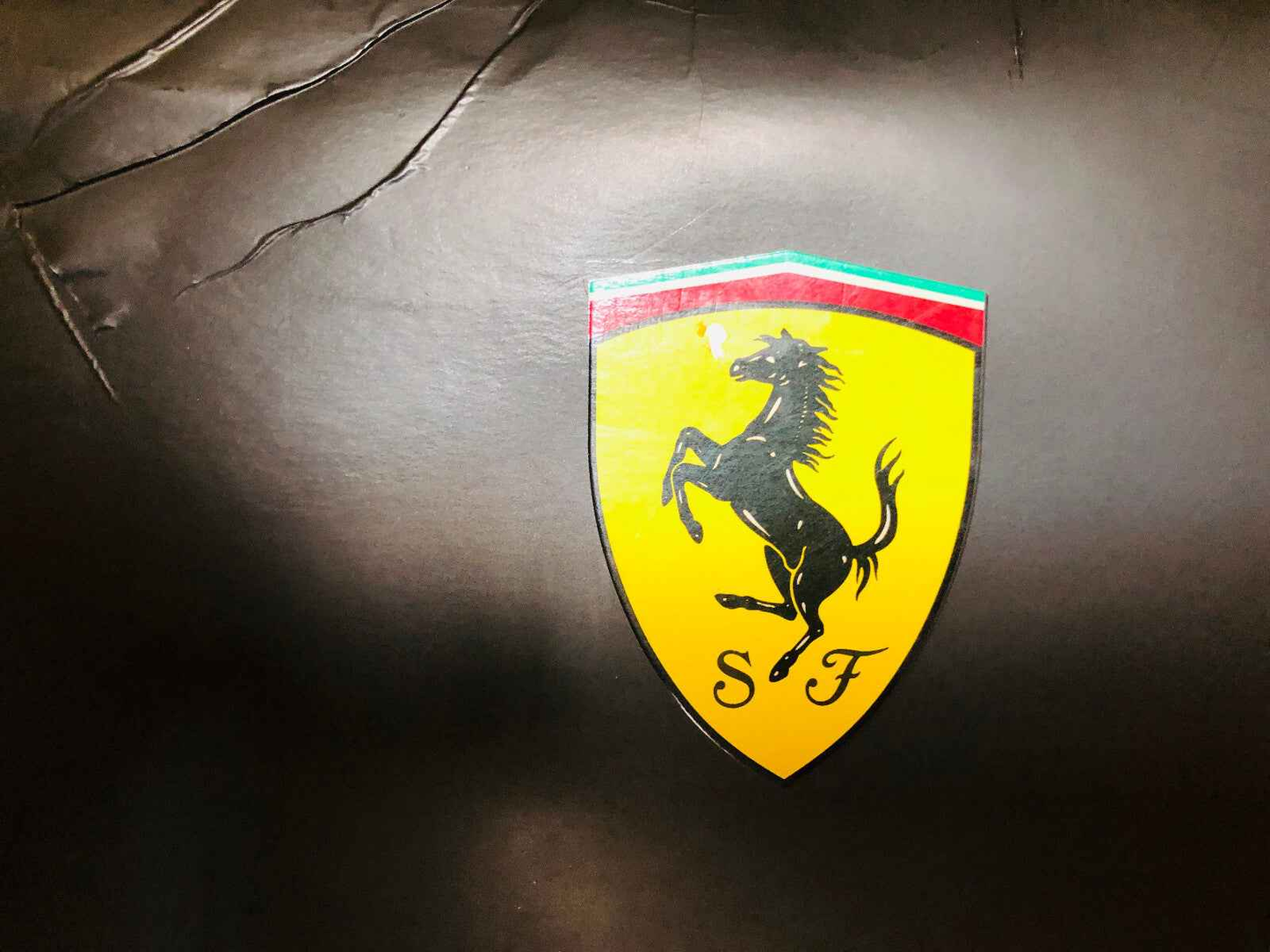 Logo Ferrari su sfondo nero, simbolo del profumo Ferrari Black Vintage