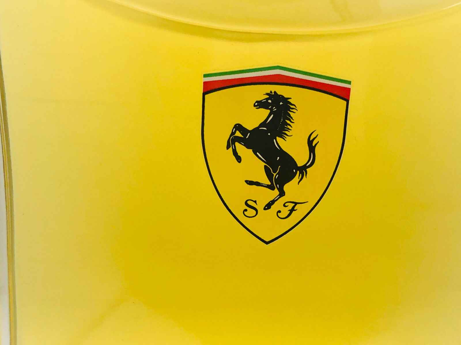 Flacone giallo del profumo Ferrari Red con il logo del cavallino rampante