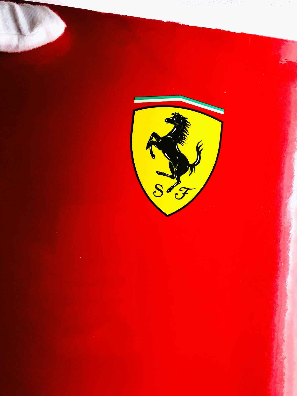 Logo Ferrari su sfondo rosso brillante del profumo Ferrari Red con icona del cavallino rampante