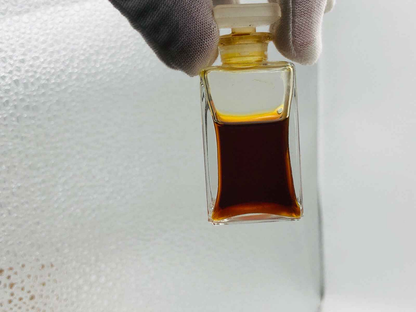 Flame Of Hope Parfum in elegante flacone trasparente con liquido marrone scuro