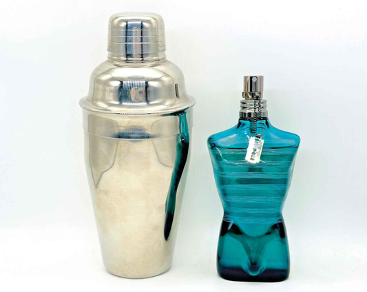 Profumo Le Male Terrible di Jean Paul Gaultier in flacone azzurro accanto a uno shaker argento