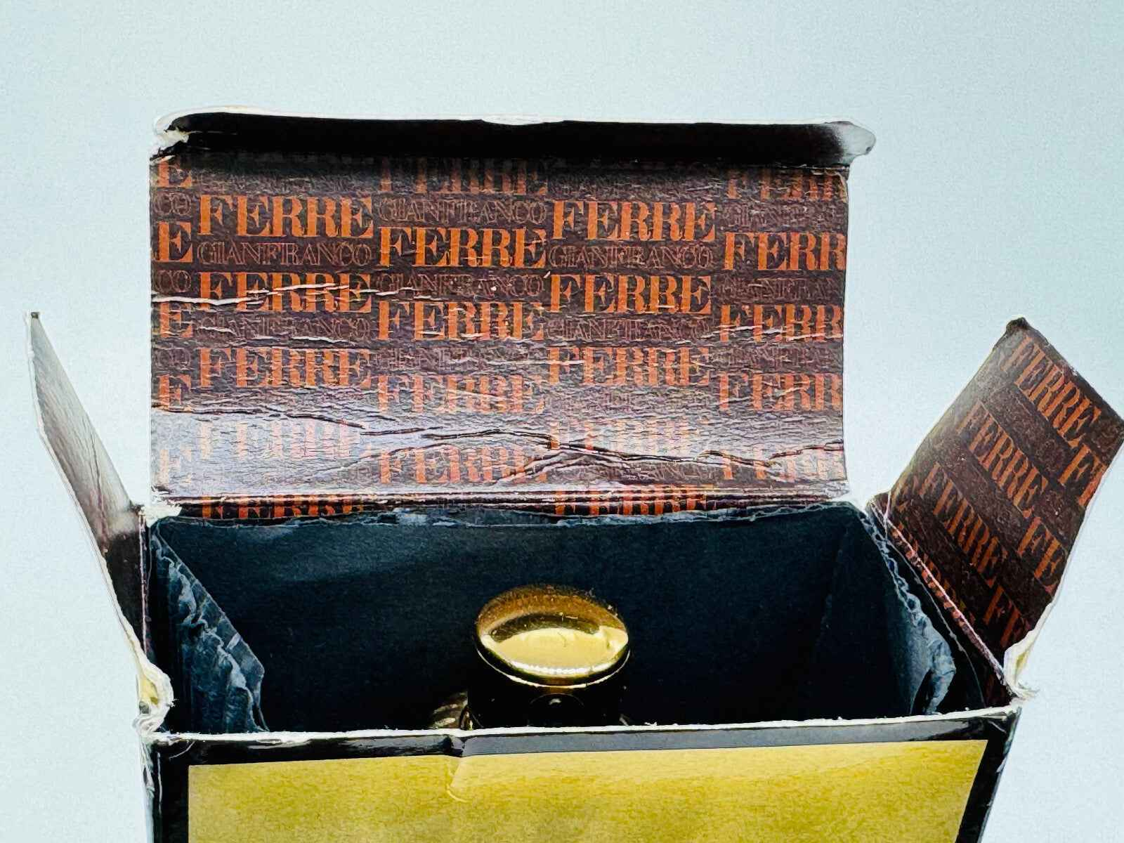 Scatola vintage del profumo Ferre Pour Homme con interno in vista e flacone parzialmente visibile
